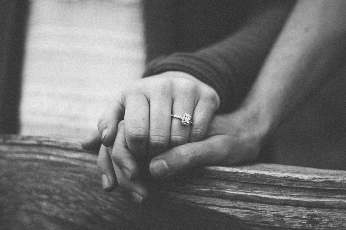 A couple holding hands with a wedding ring visible
