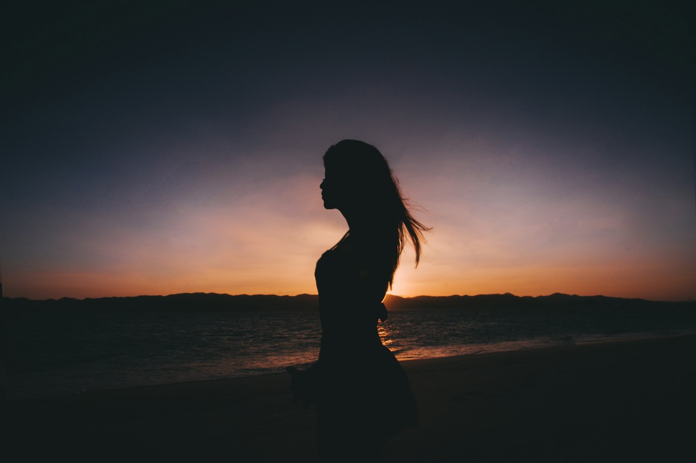 Silhouette photography of woman standing near seashore
