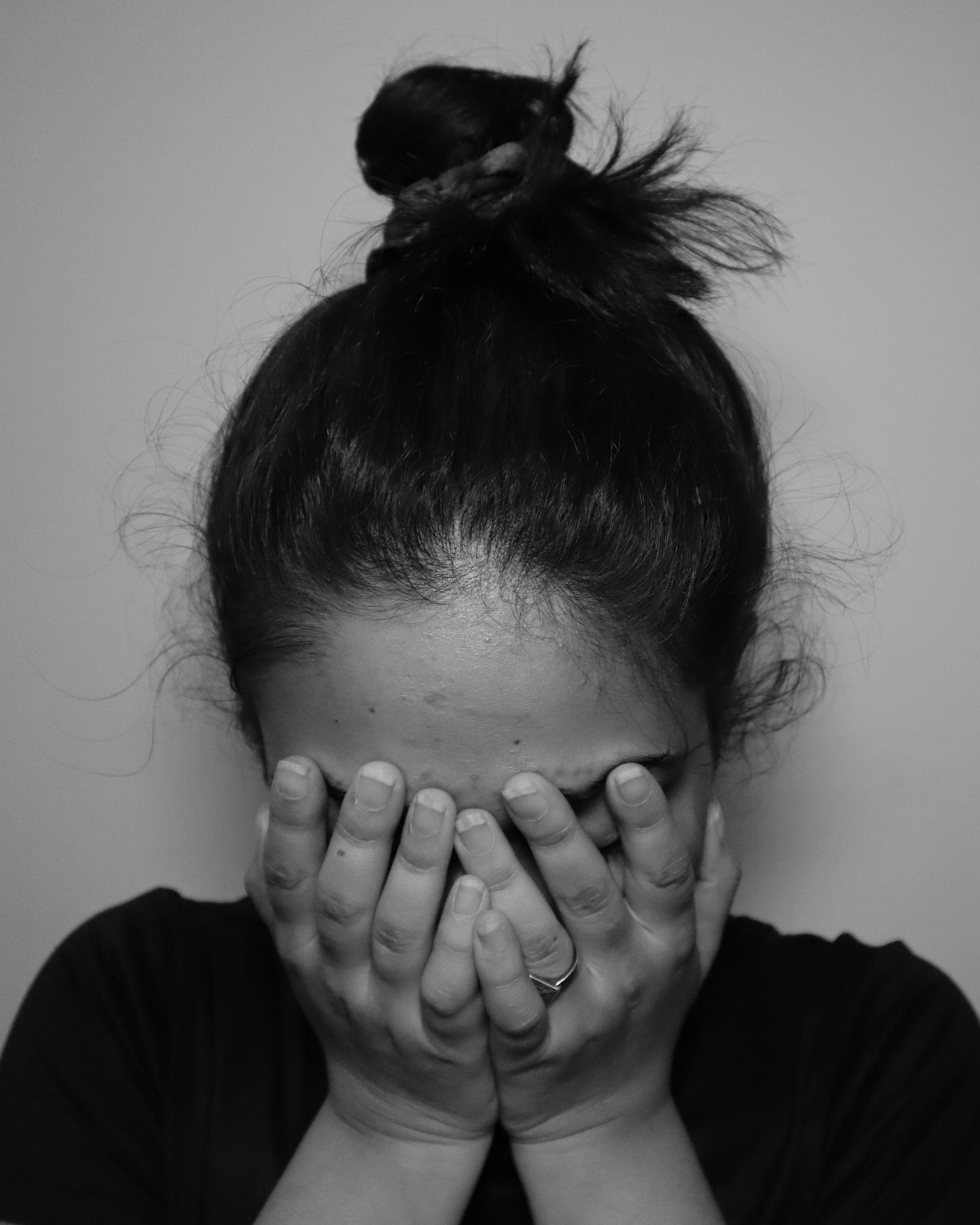 A woman covering her face with her hands